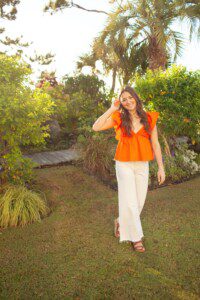 orange ruffle shirt with white pants outfit for senior pictures